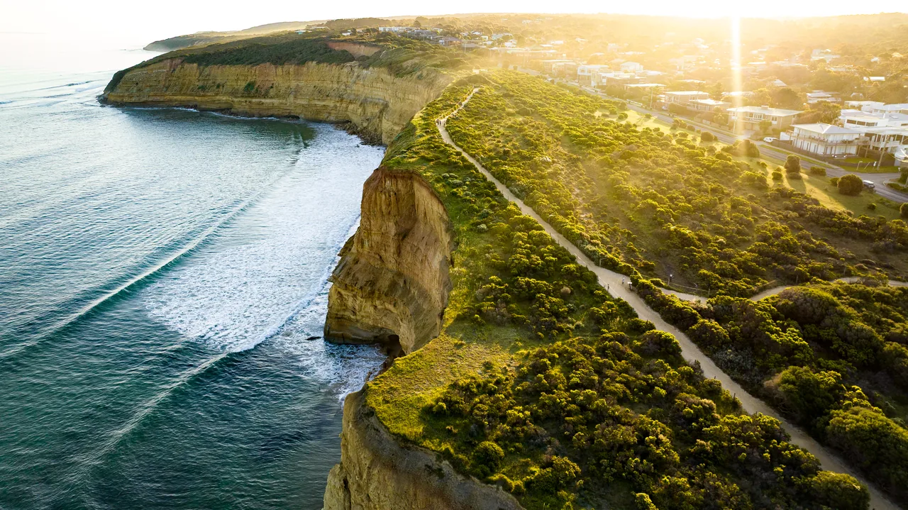 Aerial view of Surf Coast cliffs and surf at sunset